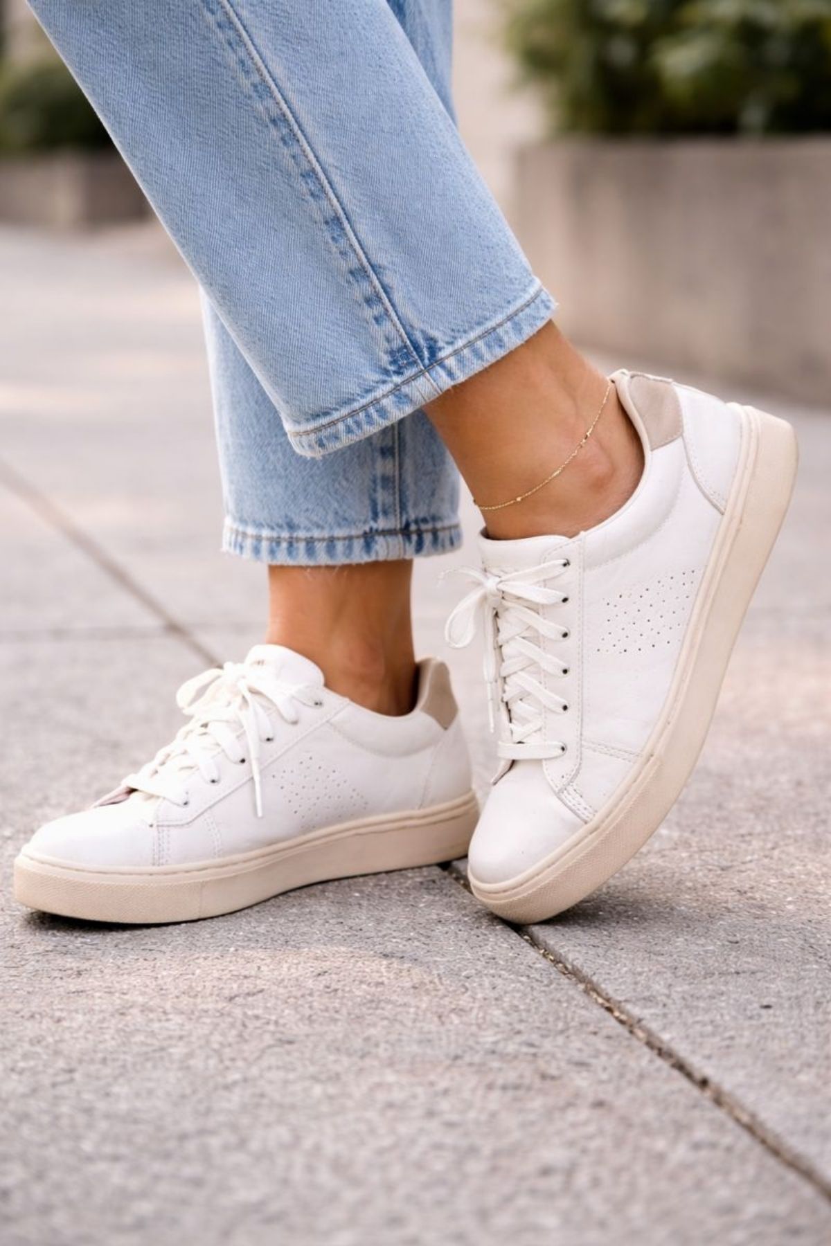 Close-up of white comfortable sneakers styled with light blue cropped jeans, creating a clean and effortless casual look for everyday wear.
