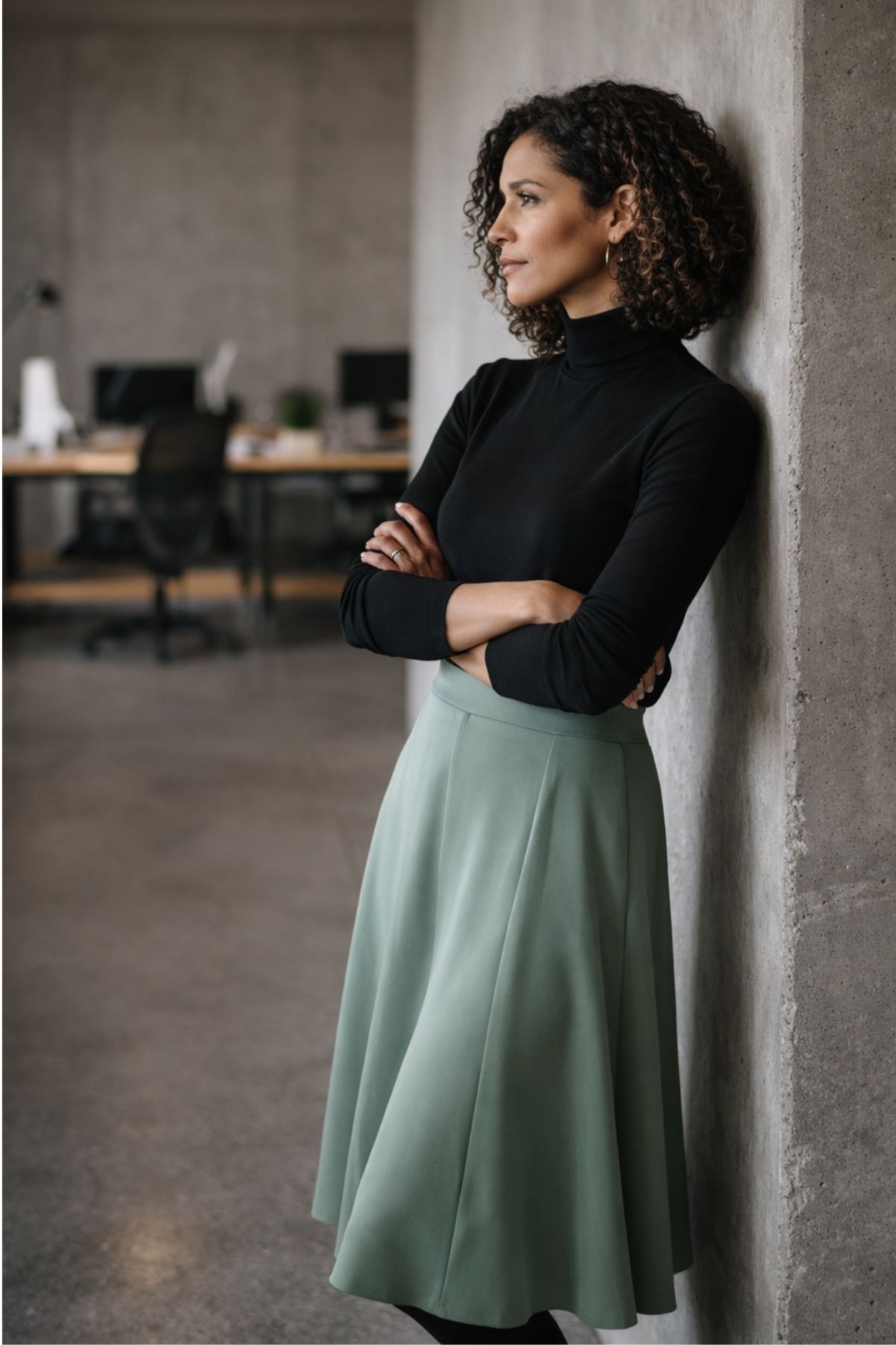 Soft green midi skirt paired with a black top for a balanced, professional work outfit