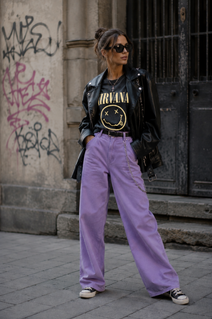 Rebel fashion archetype wearing lavender wide-leg jeans with a black graphic T-shirt, leather biker jacket, and sneakers for an edgy street style look.